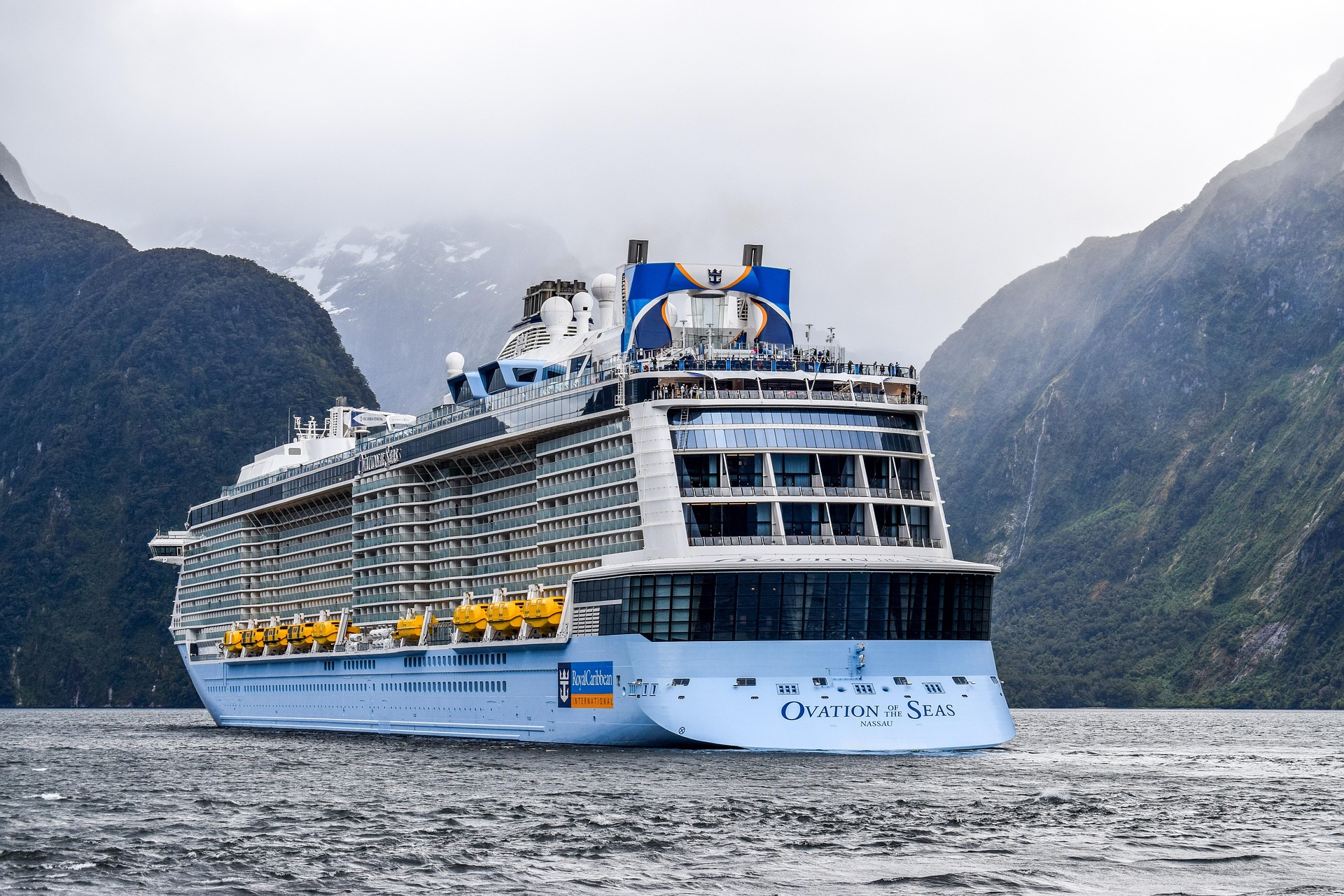 Ocean cruise ship sailing through a scenic fjord surrounded by mountains